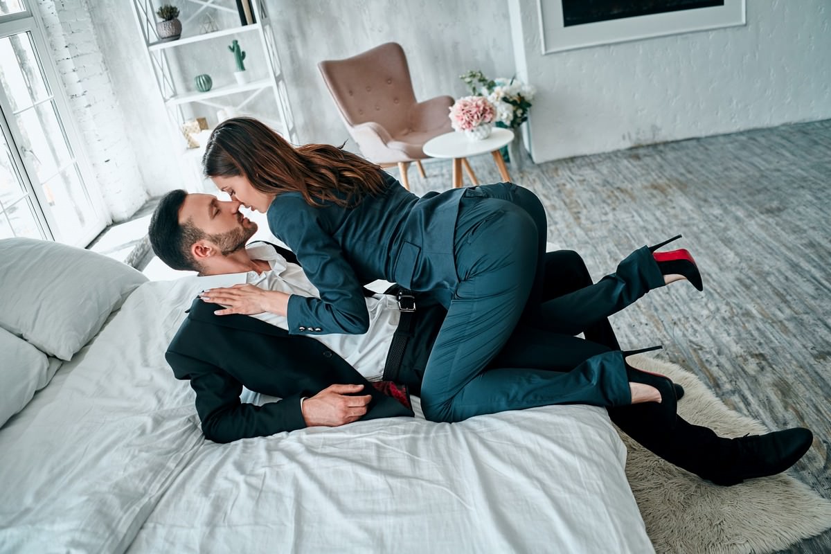 business woman man kissing bed